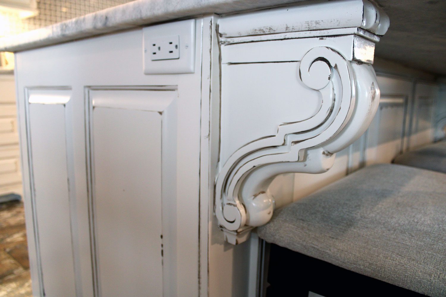A hand-carved corbel detail on custom cabinetry built by Custom Wordworks